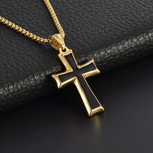 Minimalist gold stainless steel cross necklace with black enamel inlay on leather background