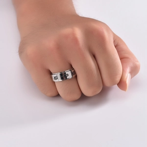 Macro detail of stainless steel rotating ring with etched Eye of Horus and Ankh symbols