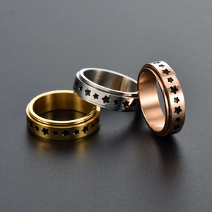 Minimalist stainless steel spinner ring set with star patterns in gold, silver, and rose gold