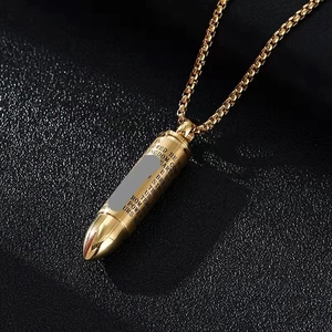 Macro shot of gold bullet pendant with engraved English scripture on bead chain