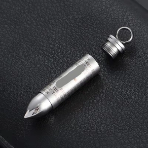 Macro shot of silver stainless steel bullet pendant with engraved Lord's Prayer text