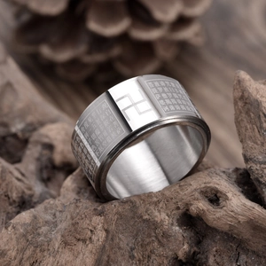 Close-up of titanium steel ring with engraved Buddhist Heart Sutra on a wooden base