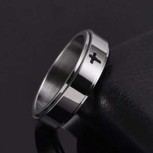 Detailed side view of silver titanium steel spinner ring with black cross engraving