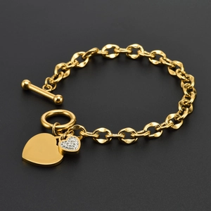 Détail du bracelet cœur en or rose avec fermoir OT et breloques en cristal brillant