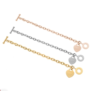 Détail de bracelets à fermoir OT en or, argent et or rose avec gravure en forme de cœur