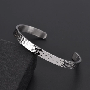 Detail showing the hammered texture and polished inner surface of the silver open cuff bracelet