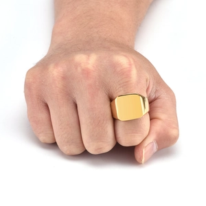 Close-up of polished gold square signet ring for men on finger in minimalist style