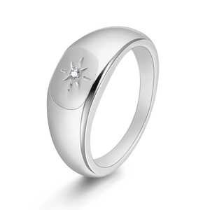 Macro shot of silver signet ring with starburst engraving and a tiny centered zircon stone
