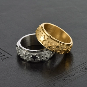 Macro shot of silver and gold stainless steel spinner rings with embossed star patterns