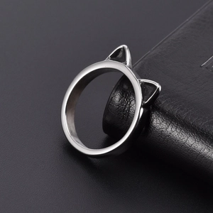 Anello con orecchie di gatto in acciaio lucido su superficie di pelle nera