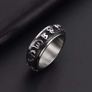 Rotating stainless steel Pixiu ring for men with engraved mantra on black background