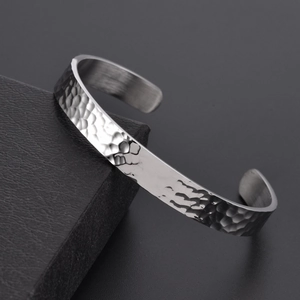 Close-up of silver hammered texture on minimalist stainless steel open cuff bracelet