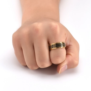 Men's gold stainless steel spinner ring with black Celtic knot engraving on white background