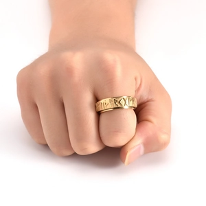 Detail of gold Viking rune spinner ring showing Nordic engravings on stainless steel band