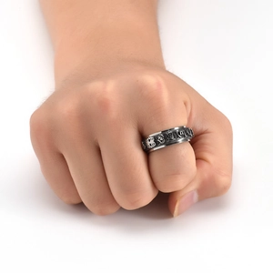 Detailed close-up of retro stainless steel spinning ring with engraved relief patterns