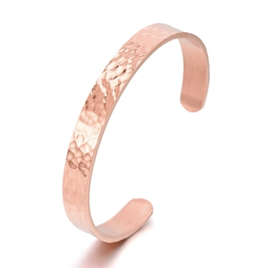 Detail of rose gold hammered cuff bracelet showing textured metal finish and open design