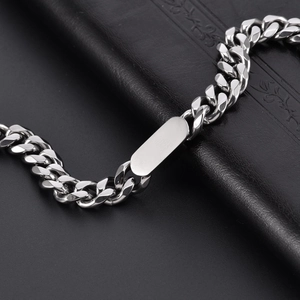 Dettaglio macro del bracciale cubano in acciaio al titanio lucido con piastra metallica