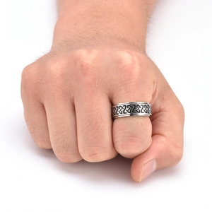 Gros plan d'une bague rotative viking en acier avec des motifs de nœuds celtiques noirs