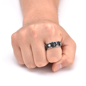Detail of spinning stainless steel star ring worn on hand with retro silver and black finish