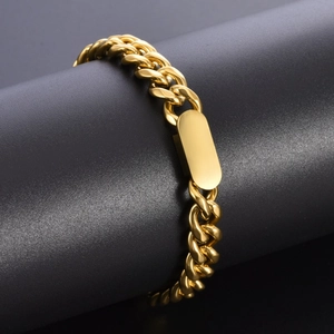 Macro di bracciale a catena cubana dorata con piastrina lucida su supporto scuro