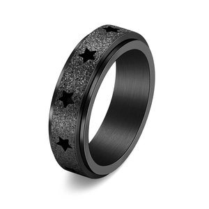 Détail d'une bague rotative noire avec finition mate scintillante et motifs d'étoiles