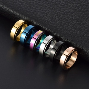 Minimalist stainless steel spinner rings in six colors shown on elegant black leather display