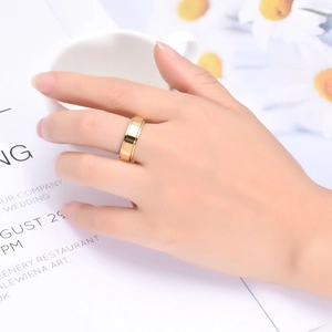 Close-up of a minimalist gold polished spinner ring worn on hand in a cozy lifestyle setting