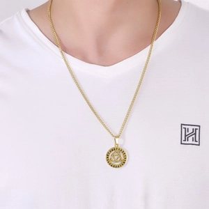 Detail of gold Viking Triquetra pendant necklace on male model with white V-neck shirt