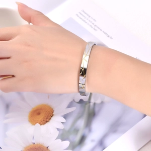 Detailed close-up of C-shaped wood grain pattern cuff bracelet on woman's wrist
