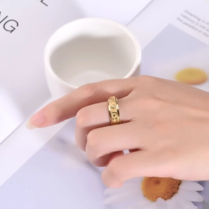 Detail of 6mm gold spinning ring with sun moon and star relief pattern on finger