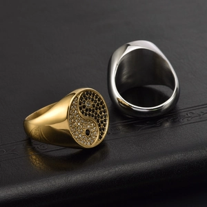 Detail of Yin Yang Tai Chi rings in gold and silver with black and white zircon inlay