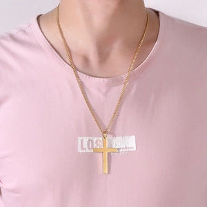 Close-up of a minimalist polished gold cross pendant necklace worn by a female model