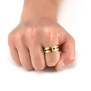 Close-up of men's gold stainless steel ring with black razor blade patterns on finger