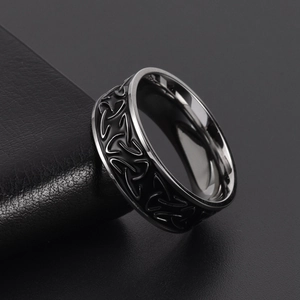 Macro view of Viking Triquetra knots on a black and silver stainless steel ring band
