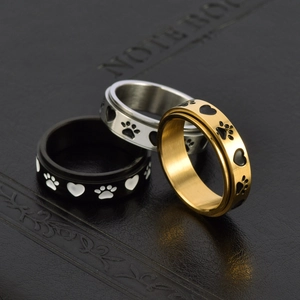 Three spinner rings in gold, silver, and black with cat paw and heart motifs