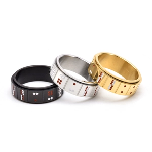 Close-up of rotatable stainless steel rings in black, silver and gold with poker dots