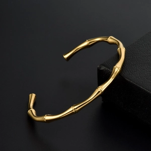 Macro di bracciale rigido dorato a forma di bambù su scatola porta gioie elegante