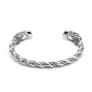 Macro detail of Nordic Viking twisted steel bangle featuring carved wolf head terminals