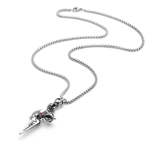 Macro detail of vintage stainless steel vajra pendant with red crystal and square box chain