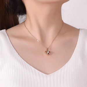 Collier cœur en or rose avec pierre de projection 100 langues sur un modèle féminin