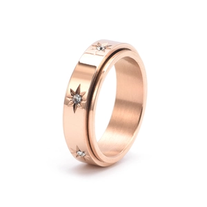 Détail d'une bague rotative or rose avec motifs d'étoiles et incrustations de zircons