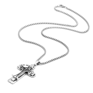 Macro shot of silver titanium steel triple layer cross pendant with black enamel engraving