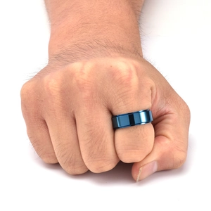 Détail d'une bague polie en acier titane bleu de 8 mm portée sur la main d'un homme