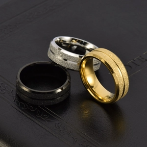 Men's matte black, gold, and silver stainless steel rings with grooved textures on leather
