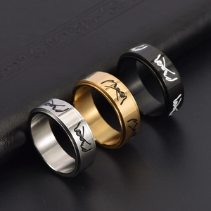Close-up of minimalist rotating rings in silver, gold, and black with pinky swear engraving