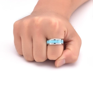 Detail of a men's tungsten ring with turquoise inlay and silver beveled edges