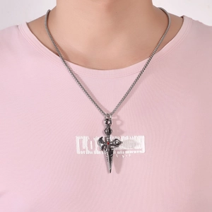 Vintage stainless steel cross dagger pendant with red gem and silver curb chain on a model