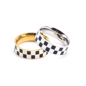 Vue détaillée de bagues en titane doré et argenté avec motif de damier noir et blanc
