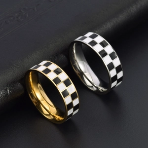 Vue macro de bagues en acier titane plaqué or 18K avec émail en damier noir et blanc