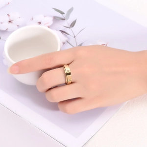 Détail d'une bague dorée rotative avec motifs d'étoiles gravés et cristaux étincelants